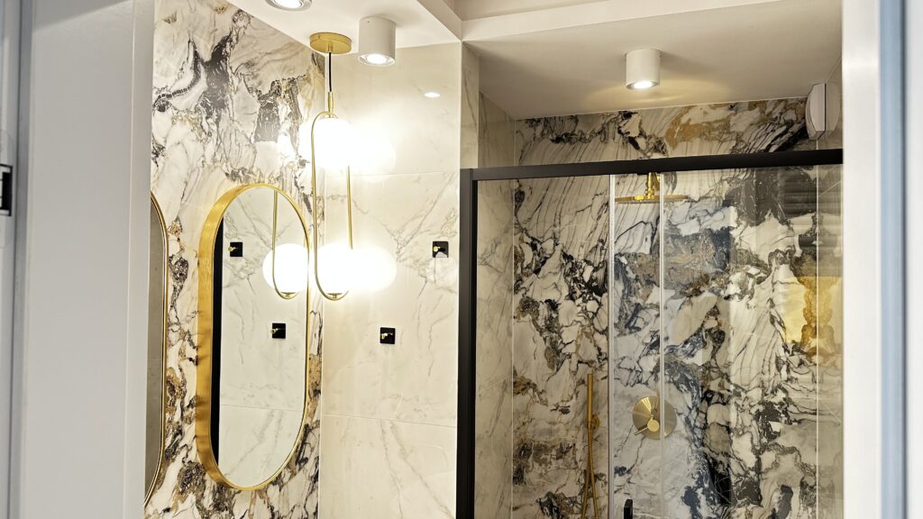 Łazienka z marmuru ze złotymi akcentami — wykończenie deweloperskie Katowice